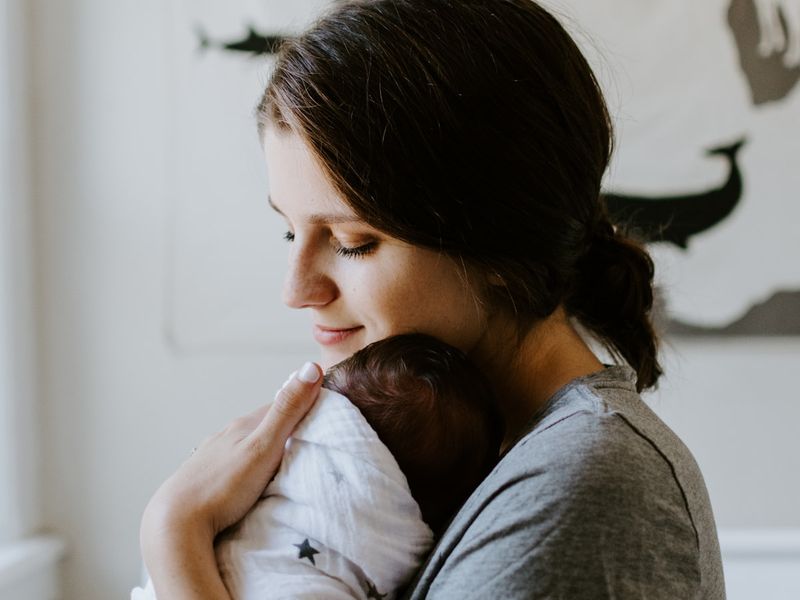 Elternteil hält schlafendes Baby